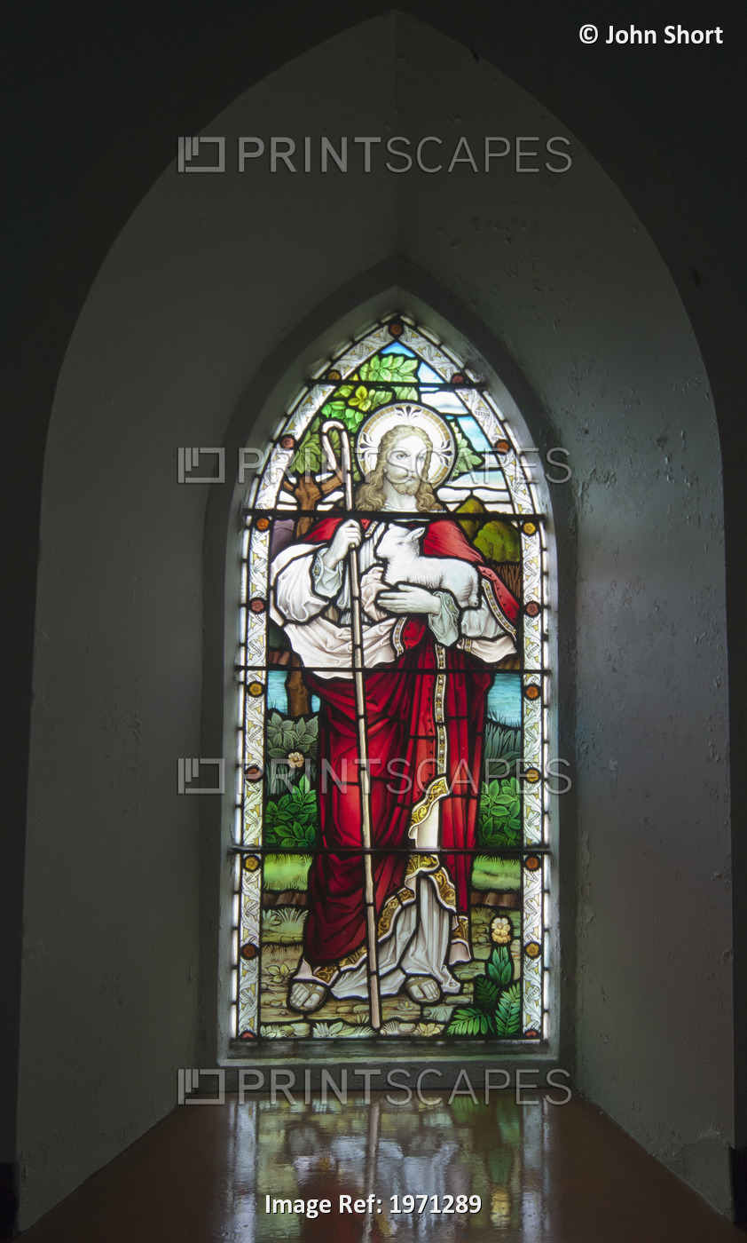 A Stained Glass Window Depicting Jesus Holding A Sheep At Church On The Beach; ...
