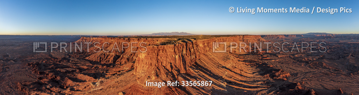 Rugged rock formation and blue sky glowing along the horizon; La Sal, Utah, ...