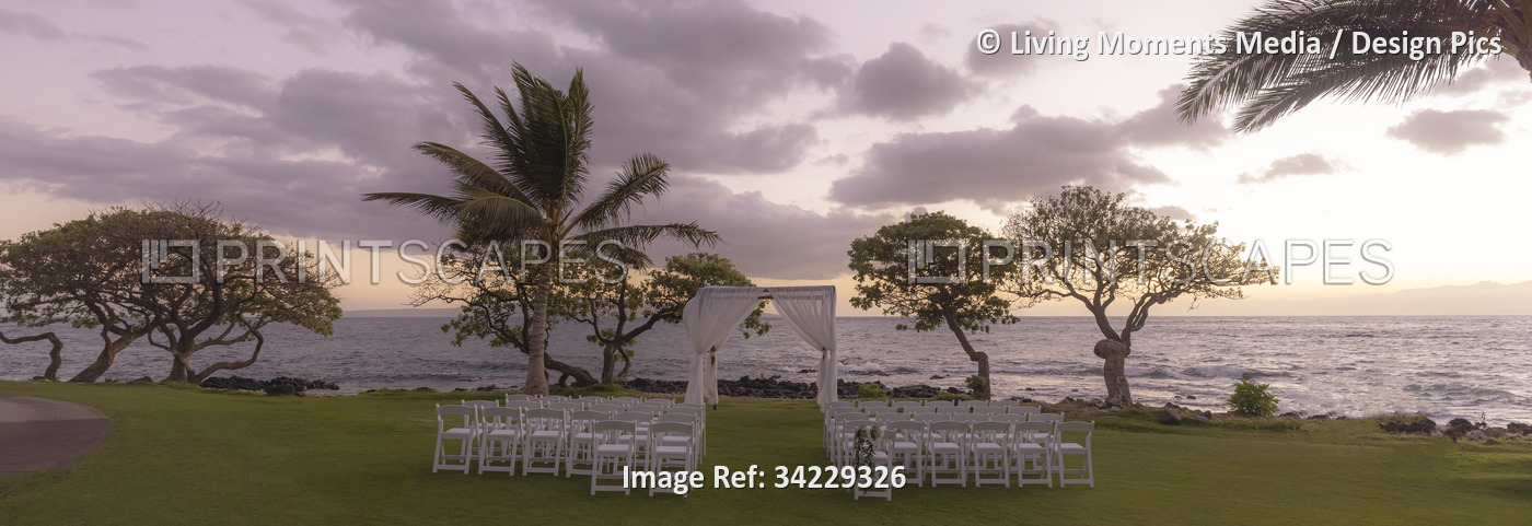 Set-up for an outdoor wedding at sunset along the coast of a hawaiian island ...