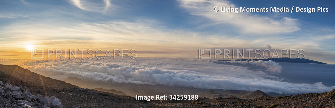 Spectacular scene of the golden twilight above the clouds at Mauna Kea with ...